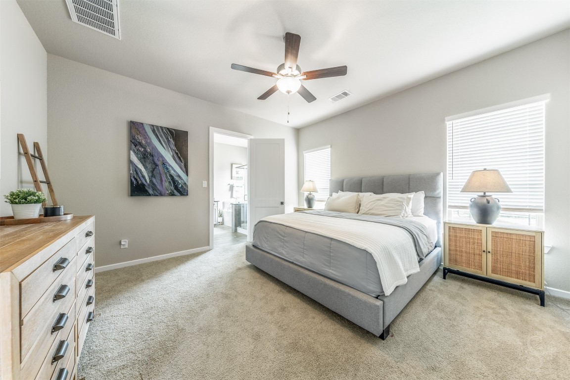 4410 Ana Ridge Lane Fulshear, TX 77441 - Photo 13 of 39 a bedroom with a large bed and a chandelier