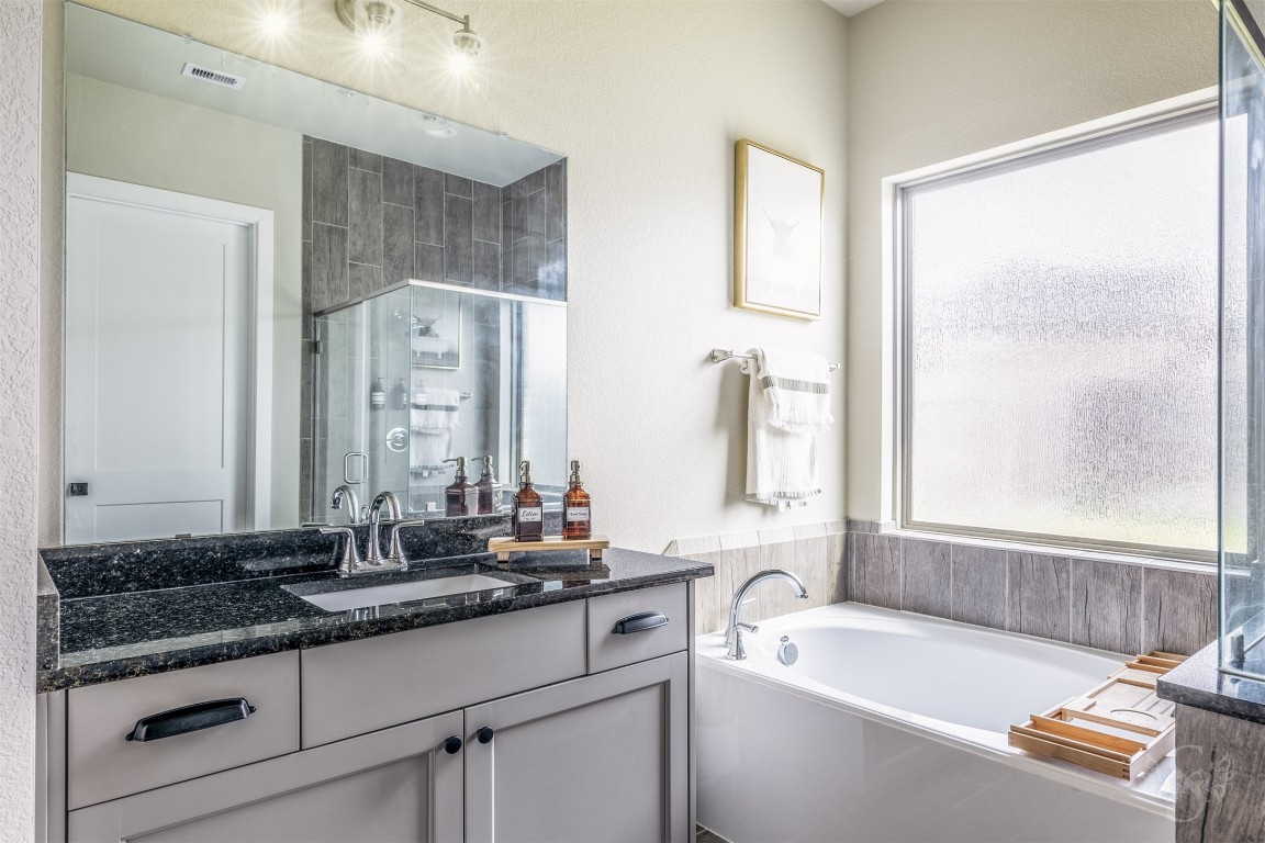 4410 Ana Ridge Lane Fulshear, TX 77441 - Photo 15 of 39 a bathroom with a granite countertop sink and a bathtub