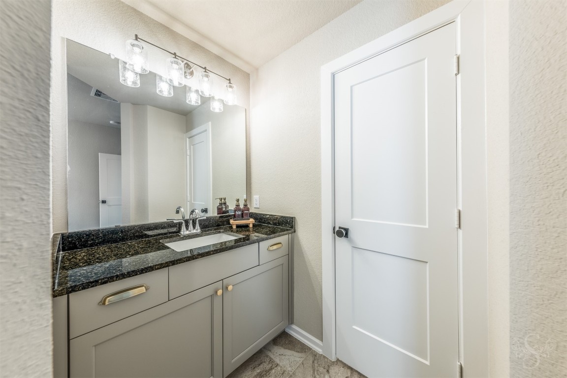 4410 Ana Ridge Lane Fulshear, TX 77441 - Photo 24 of 39 a bathroom with a granite countertop sink and a mirror
