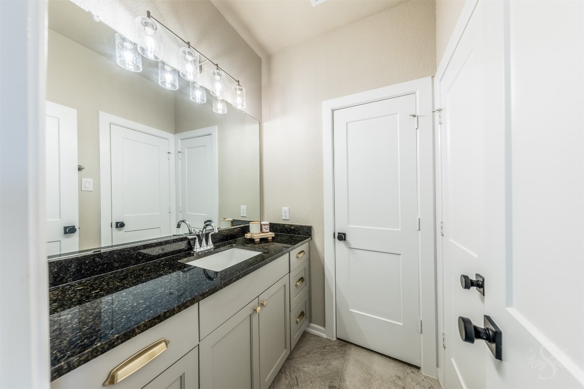 4410 Ana Ridge Lane Fulshear, TX 77441 - Photo 27 of 39 a bathroom with a granite countertop sink and a mirror