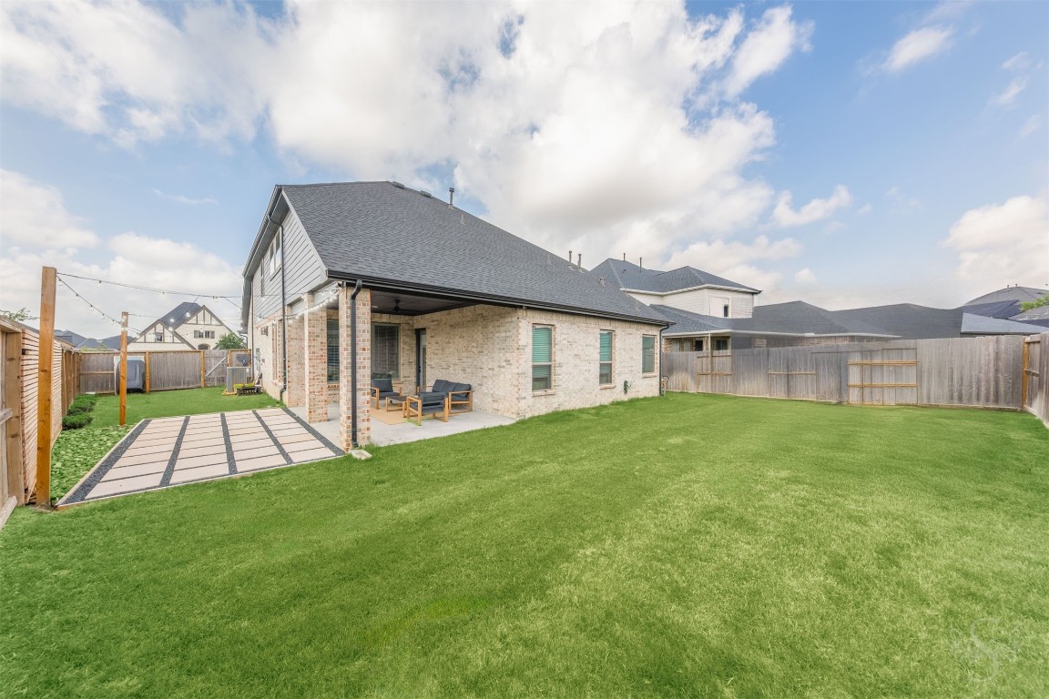 4410 Ana Ridge Lane Fulshear, TX 77441 - Photo 29 of 39 a view of a house with a backyard and a patio