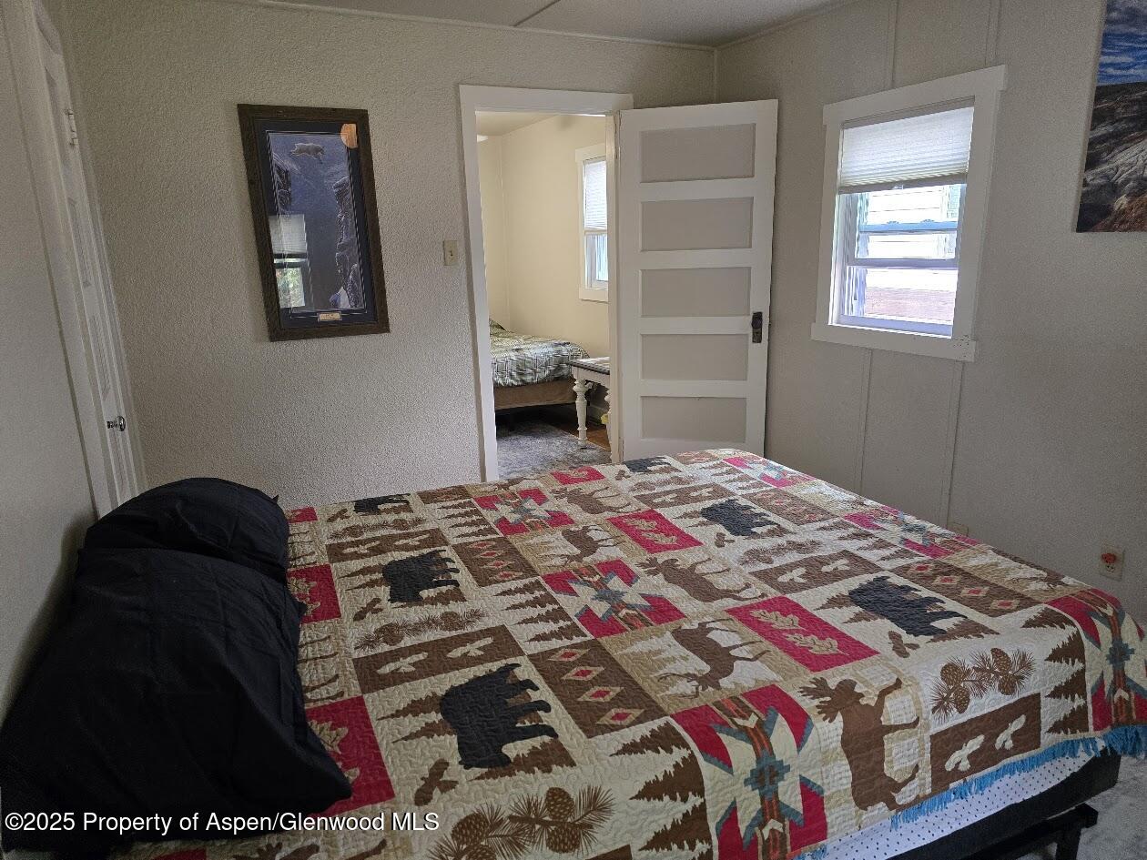 830 Breeze Street Craig, CO 81625 - Photo 15 of 18 a bedroom with a bed and a lamp on dresser