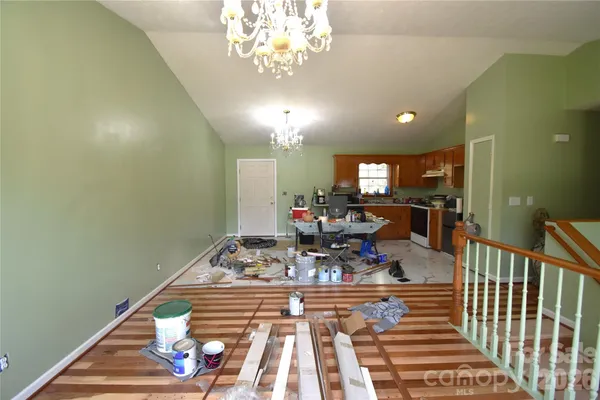 a view of a dining room with furniture a chandelier and wooden floor
