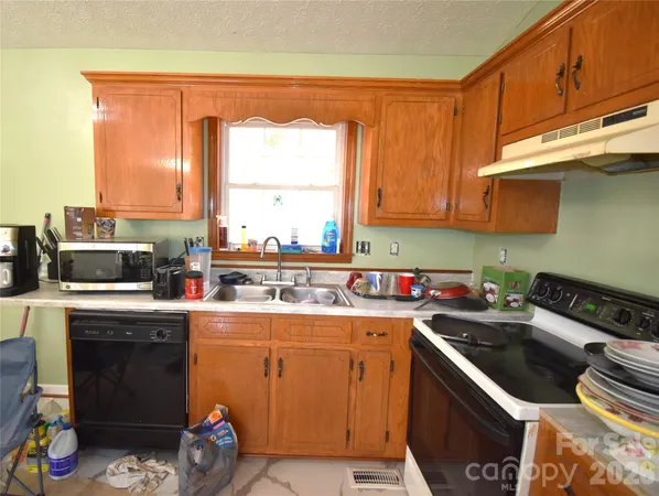 a kitchen with a sink a stove and cabinets