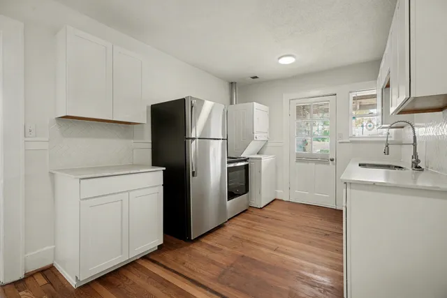 a kitchen with a refrigerator cabinets and wooden floor