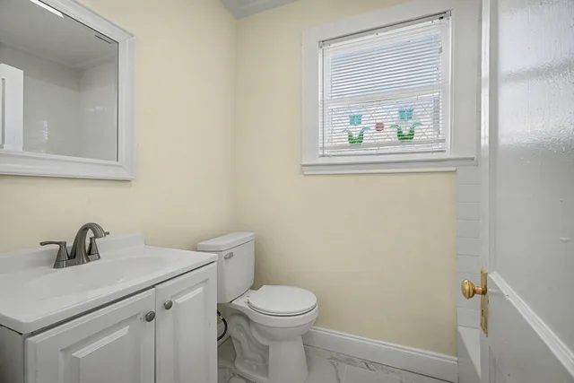 a bathroom with a toilet a sink and mirror