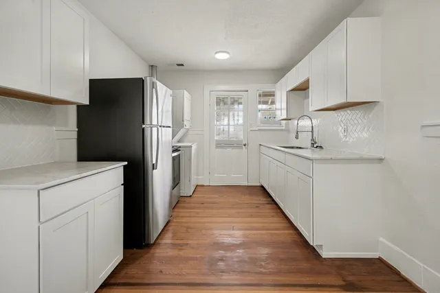 a kitchen with stainless steel appliances a refrigerator sink and cabinets