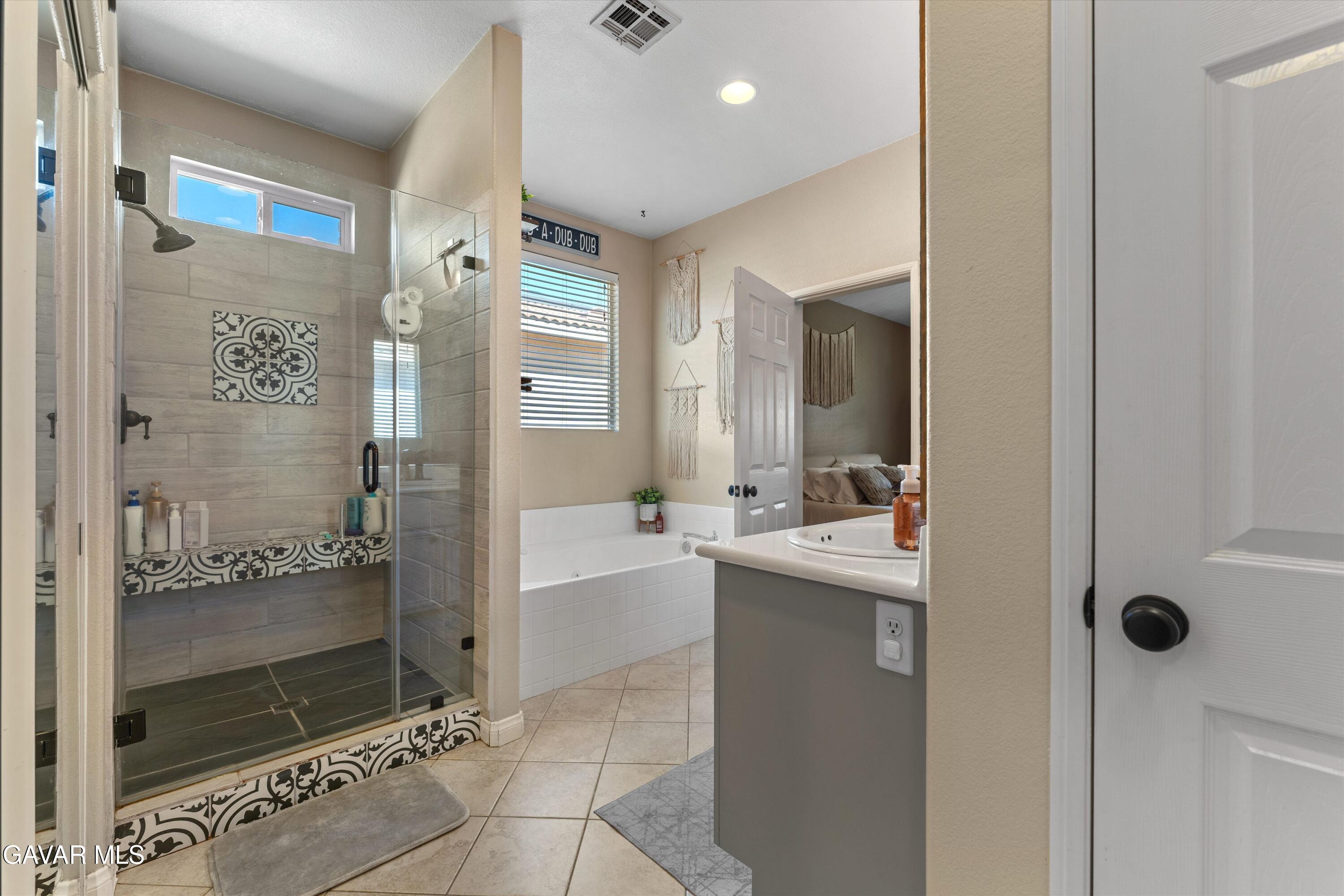 43830 Elena Court Lancaster, CA 93536 - Photo 15 of 22 a bathroom with a granite countertop sink mirror and shower