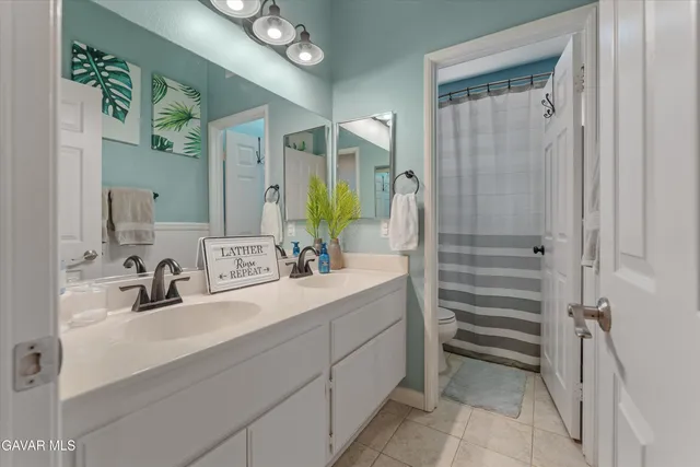 a bathroom with a double vanity sink mirror and shower
