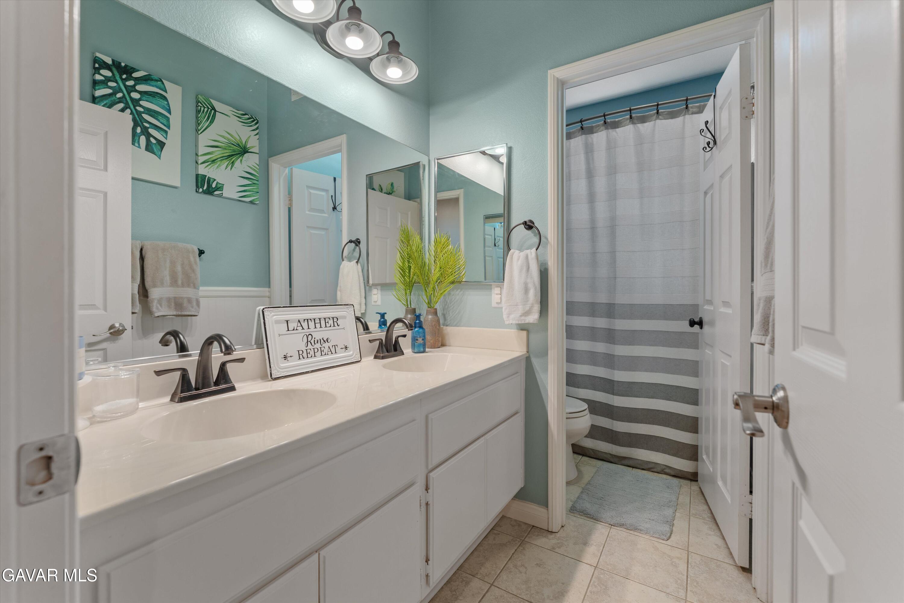 43830 Elena Court Lancaster, CA 93536 - Photo 18 of 22 a bathroom with a double vanity sink mirror and shower