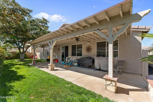 a view of a patio with chairs and table in a yard