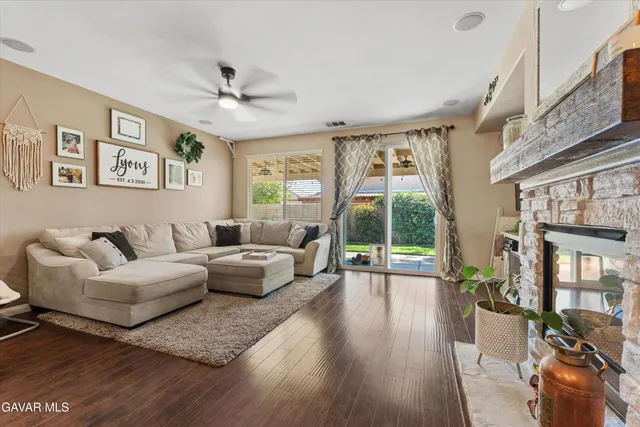 a living room with furniture large windows and wooden floor