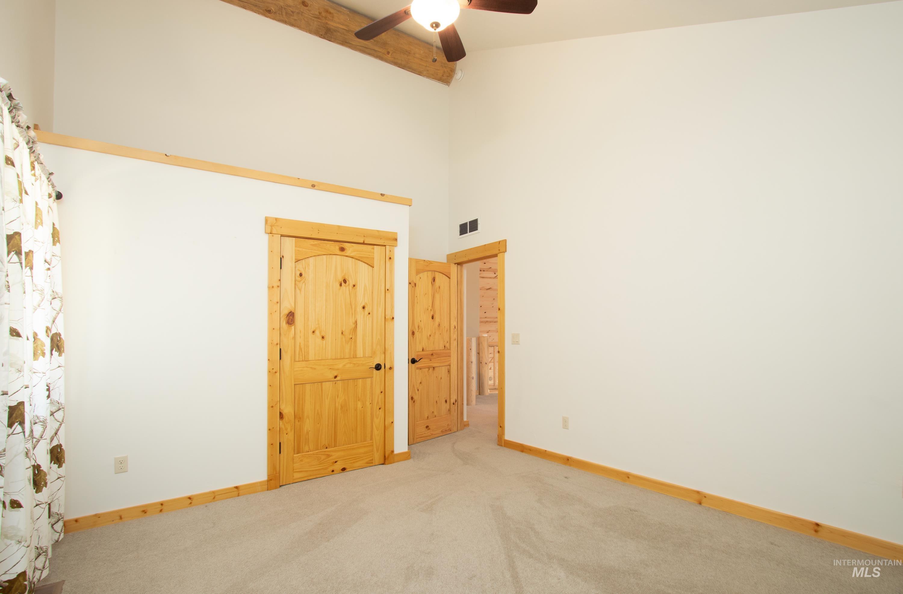 1539 West Mountain Road Cascade, ID 83611 - Photo 14 of 33 Spare room with a high ceiling, light carpet, and a ceiling fan
