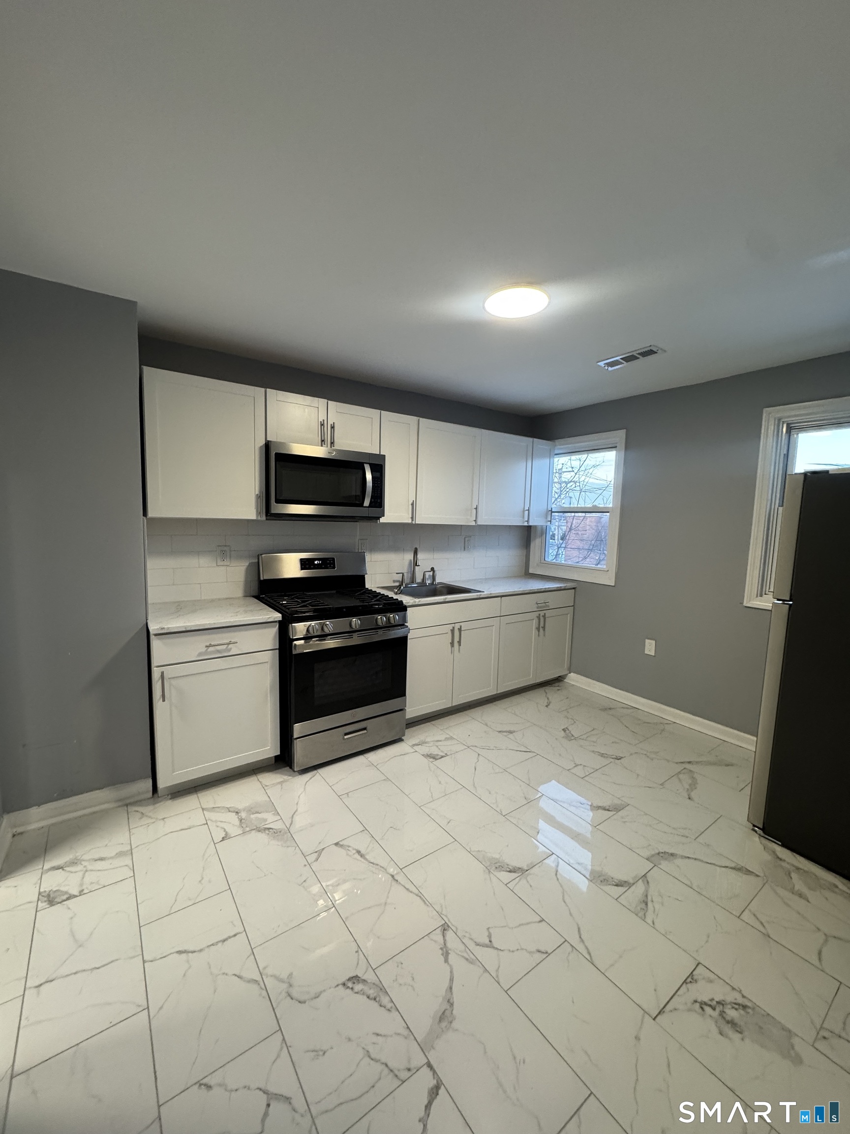 a kitchen with stainless steel appliances granite countertop a stove a sink and a refrigerator