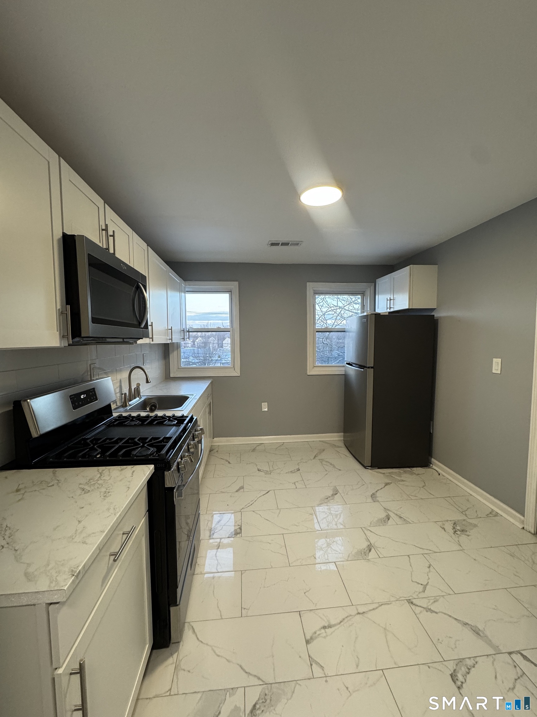 10 Lester Street, Unit 3 West Haven, CT 06516 - Photo 2 of 10 a kitchen with a stove and a refrigerator