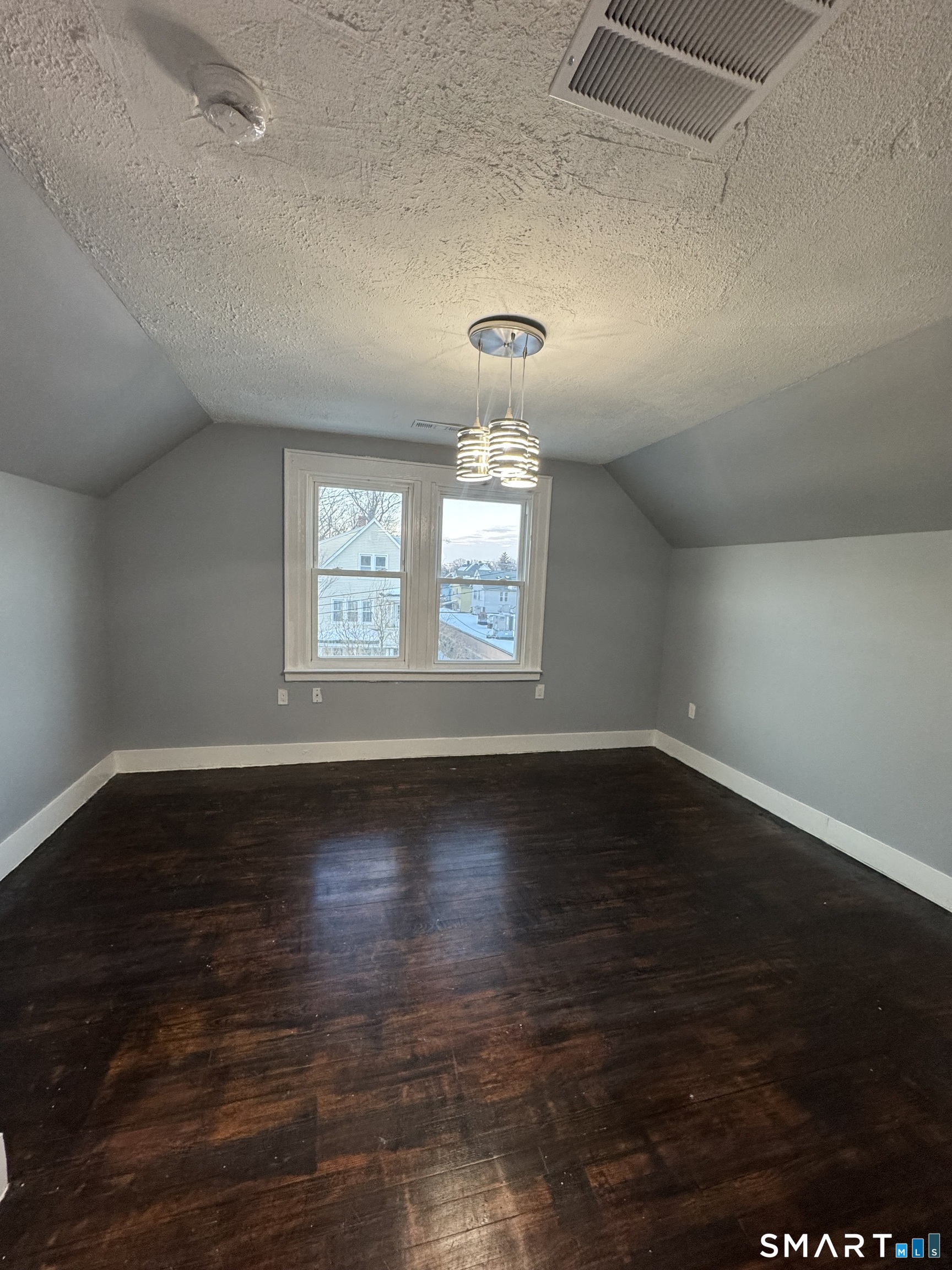 10 Lester Street, Unit 3 West Haven, CT 06516 - Photo 4 of 10 a view of an empty room with wooden floor and a window