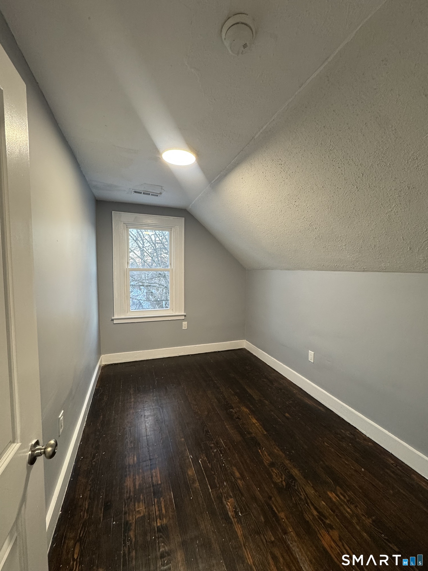10 Lester Street, Unit 3 West Haven, CT 06516 - Photo 7 of 10 an empty room with wooden floor and windows