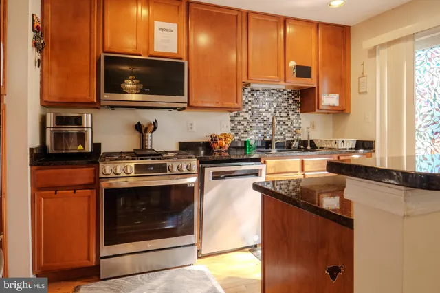 a kitchen with stainless steel appliances granite countertop a sink stove and microwave