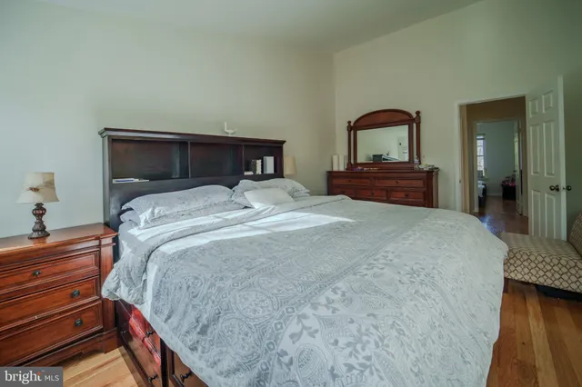 a bedroom with a bed and wooden floor