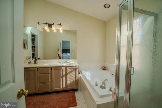 a bathroom with a tub sink and mirror
