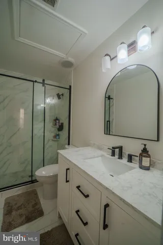 a bathroom with a sink a toilet and shower