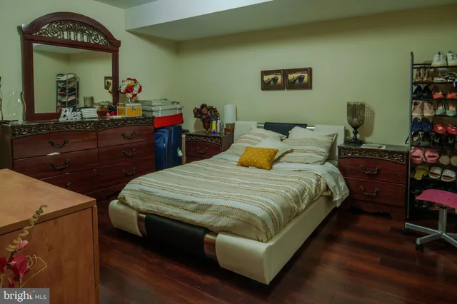 a bedroom with bed and a mirror on dresser