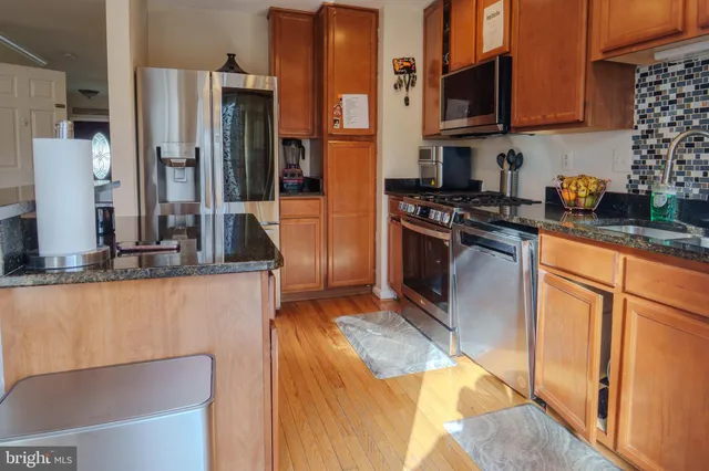 a kitchen with stainless steel appliances granite countertop a stove a sink and a refrigerator