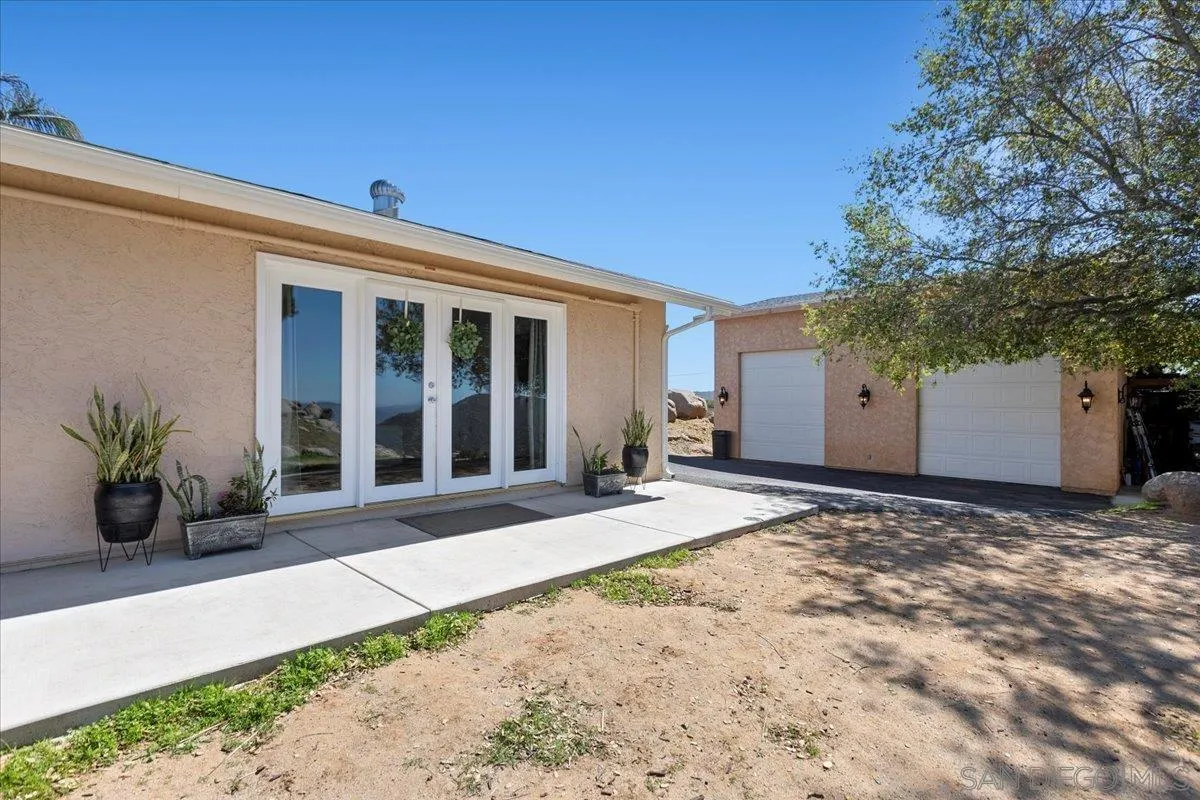 20403 Rancho Villa Road Ramona, CA 92065 - Photo 13 of 66 a view of a house with a backyard and floor to ceiling window and potted plants