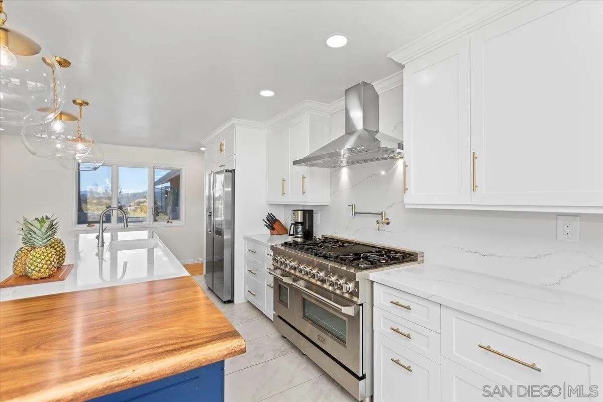 20403 Rancho Villa Road Ramona, CA 92065 - Photo 26 of 66 a kitchen with stainless steel appliances granite countertop a stove and white cabinets