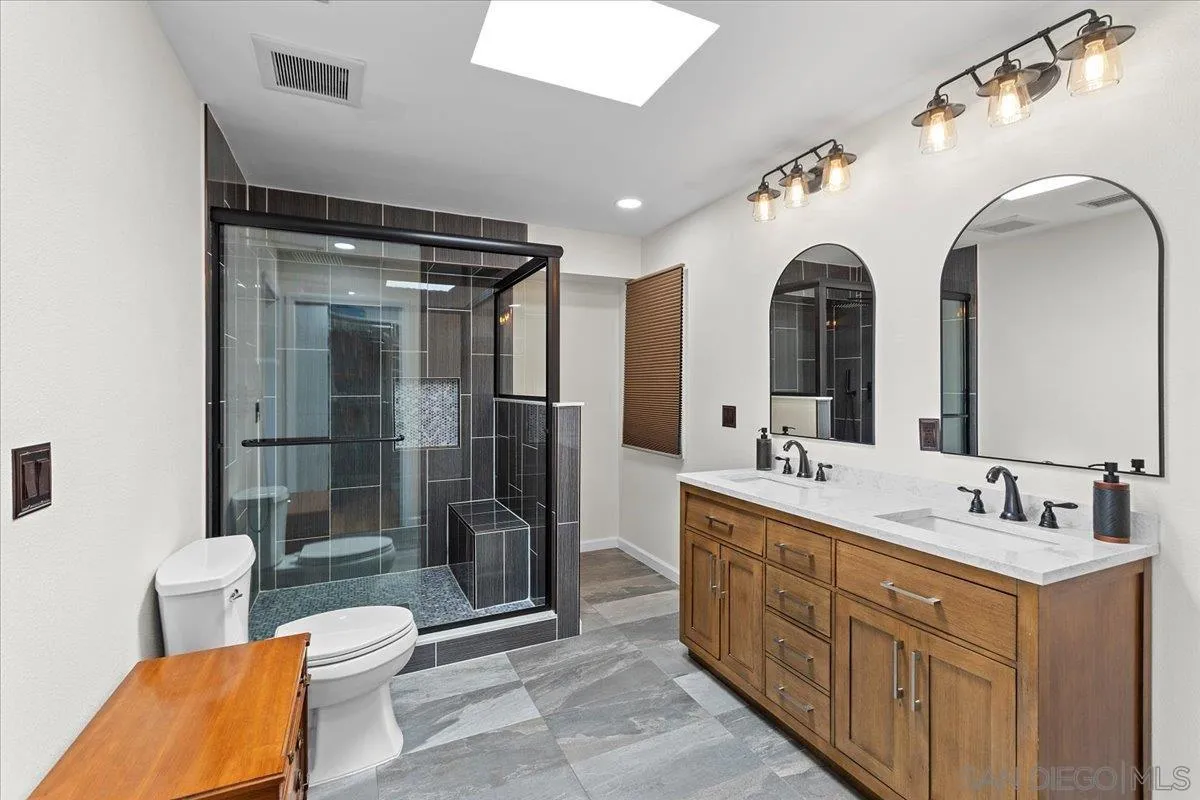 20403 Rancho Villa Road Ramona, CA 92065 - Photo 30 of 66 a spacious bathroom with a double vanity sink toilet mirror and shower