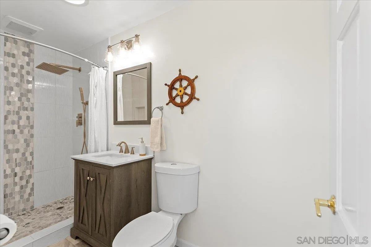 20403 Rancho Villa Road Ramona, CA 92065 - Photo 33 of 66 a bathroom with a toilet sink vanity and mirror