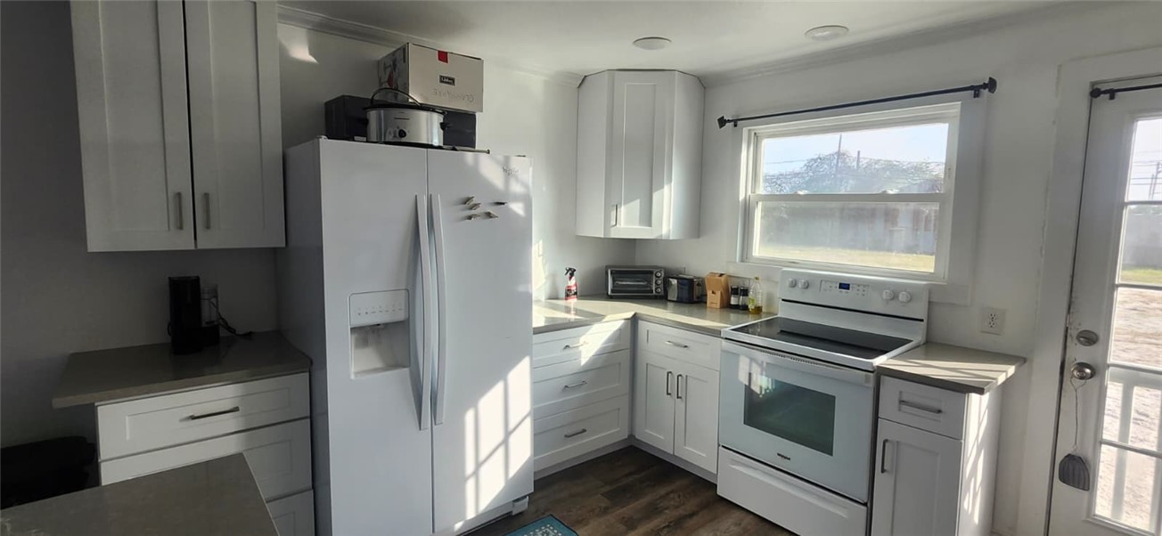 1407 Dema Street Corpus Christi, TX 78418 - Photo 13 of 19 a kitchen with white cabinets and white appliances