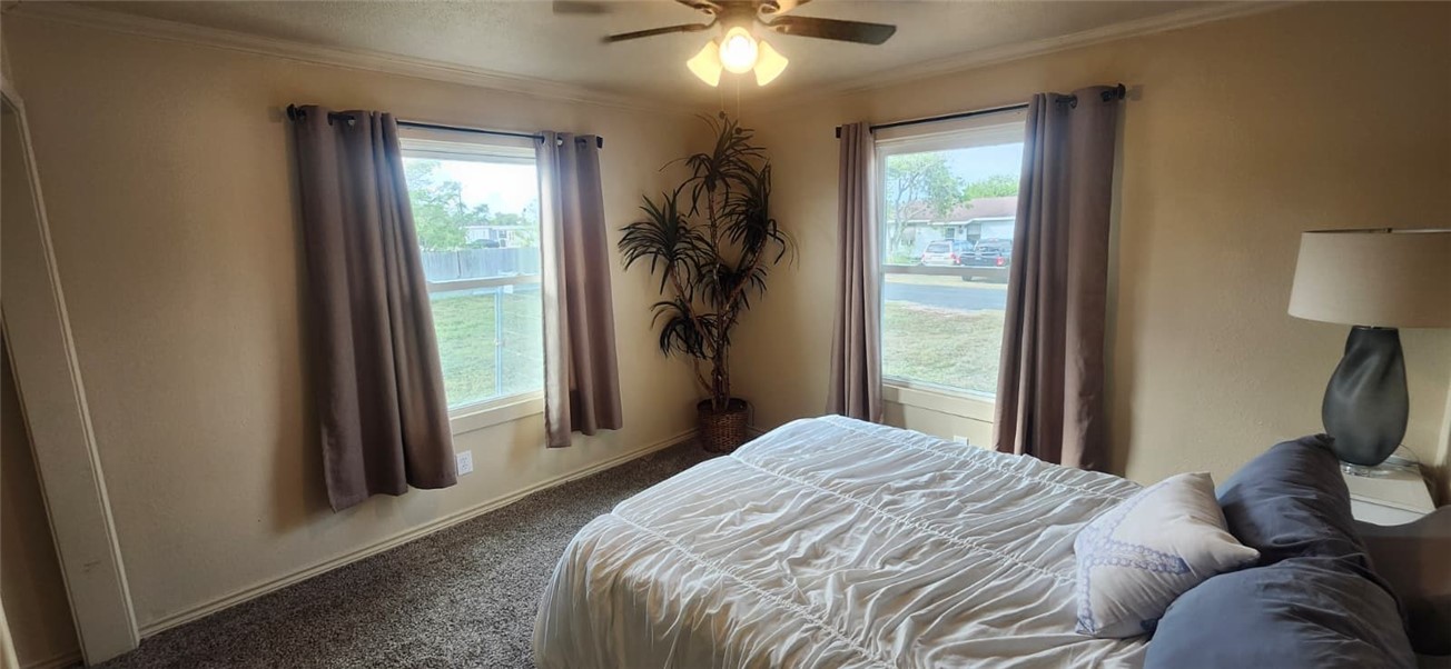 1407 Dema Street Corpus Christi, TX 78418 - Photo 17 of 19 a bedroom with a bed and a chandelier
