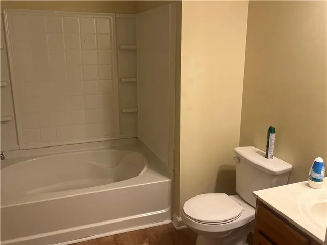 a white toilet and tub sitting next to a bathroom sink