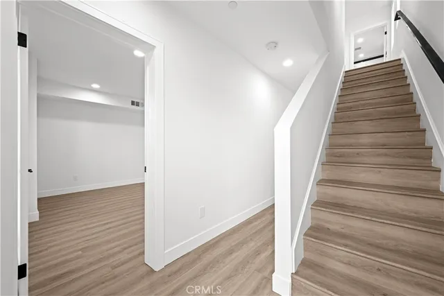 a view of a hallway with wooden floor and entryway