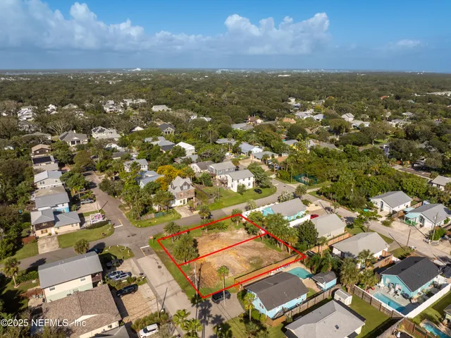 an aerial view of residential houses with outdoor space and mountain view in back