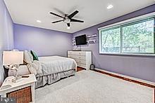 3604 Barberry Court Baltimore, MD 21208 - Photo 31 of 48 a spacious bedroom with a bed and a flat screen tv