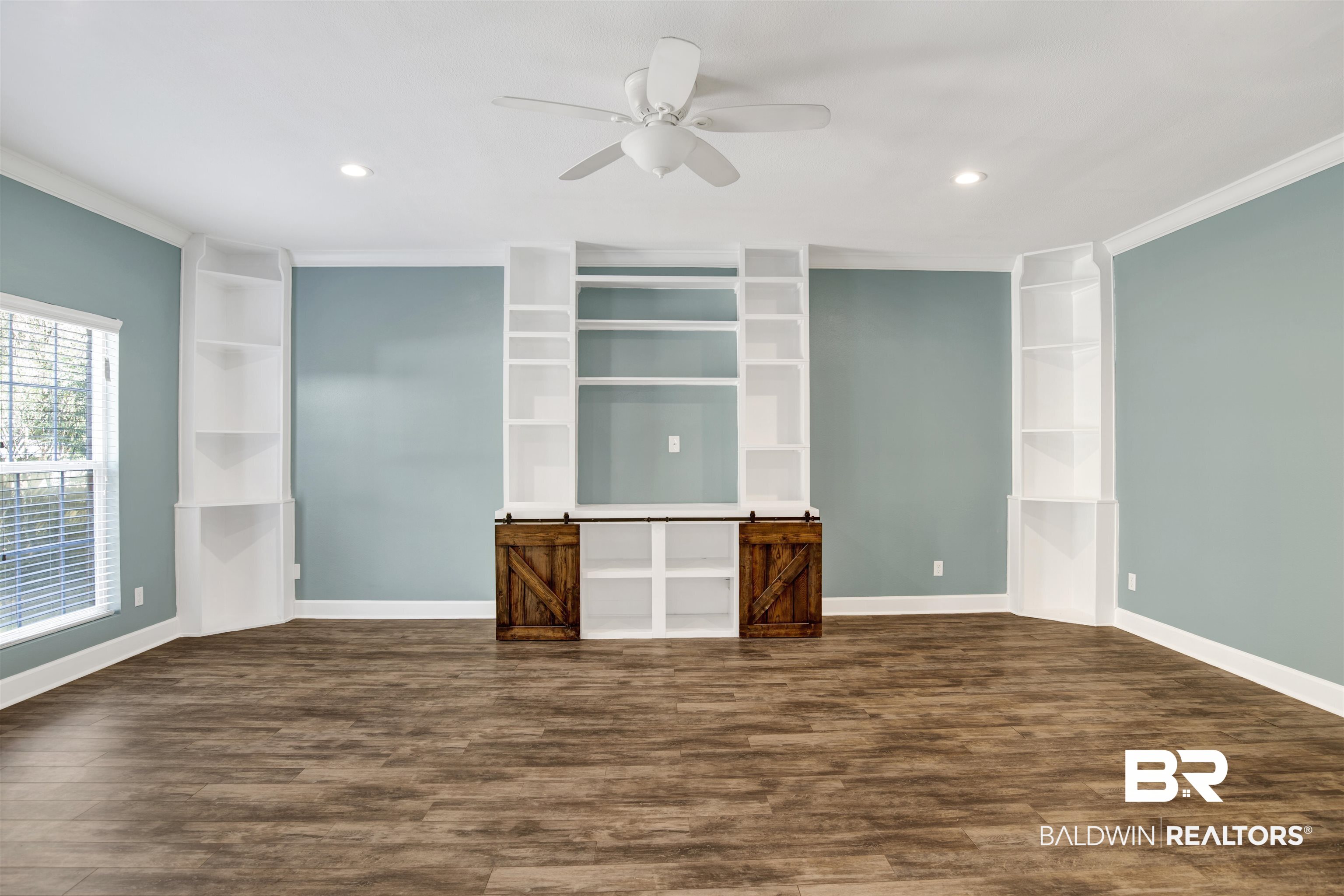 11835 Island Drive Foley, AL 36535 - Photo 32 of 53 Empty room with dark wood-style flooring, ceiling fan, ornamental molding, built in shelves, and recessed lighting