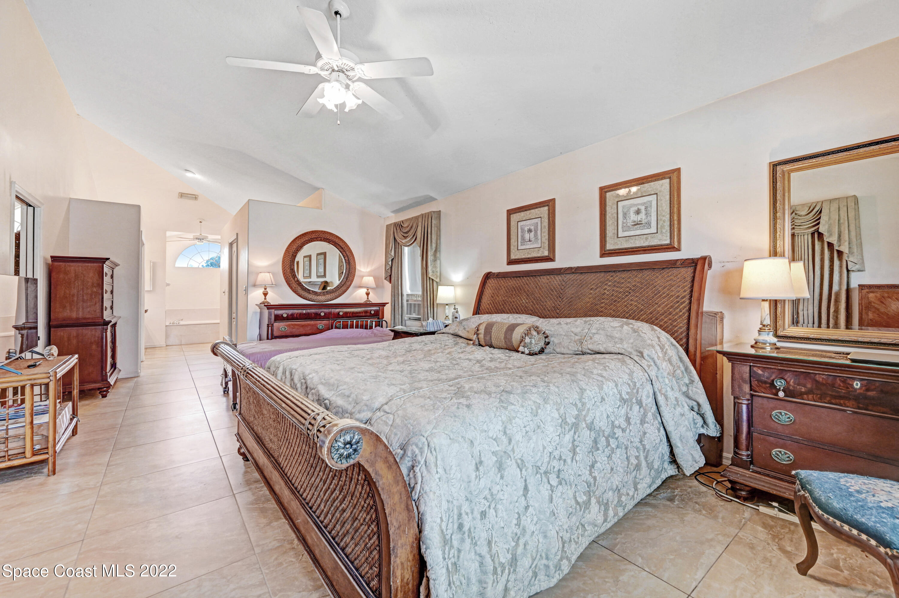 1924 Glen Meadows Circle Melbourne, FL 32935 - Photo 13 of 27 a bedroom with a bed and a chandelier