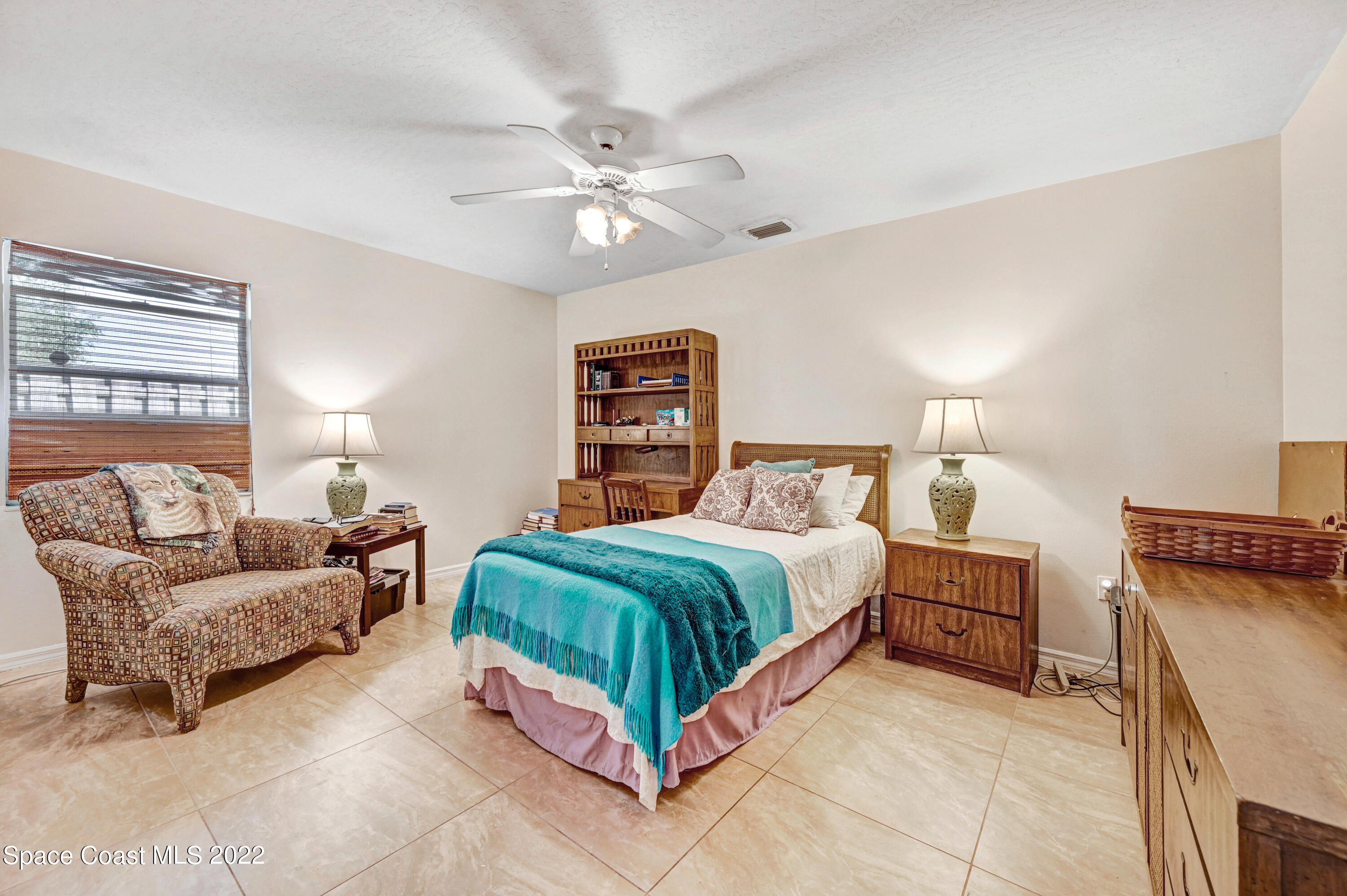 1924 Glen Meadows Circle Melbourne, FL 32935 - Photo 18 of 27 a bedroom with a bed and lamp