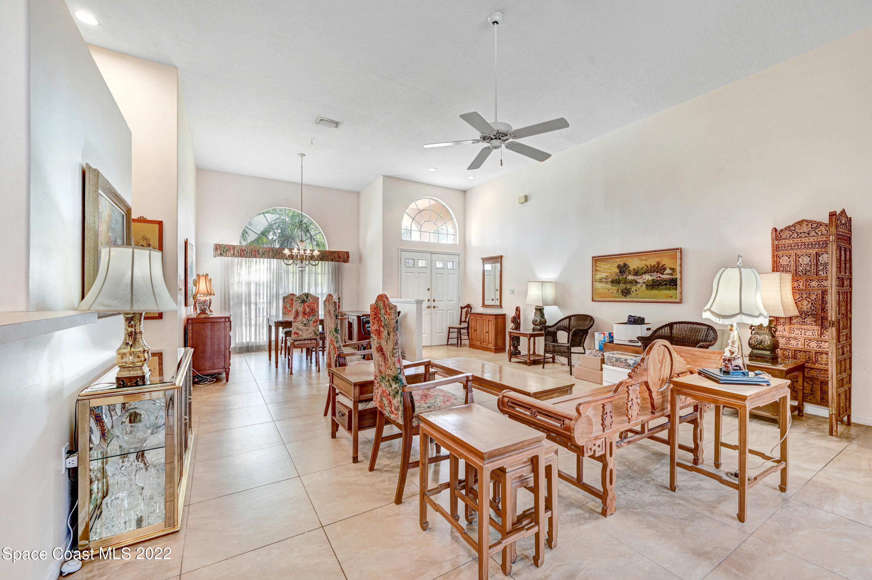 1924 Glen Meadows Circle Melbourne, FL 32935 - Photo 10 of 27 a very nice looking living room with a dining table a chandelier and a view of living room