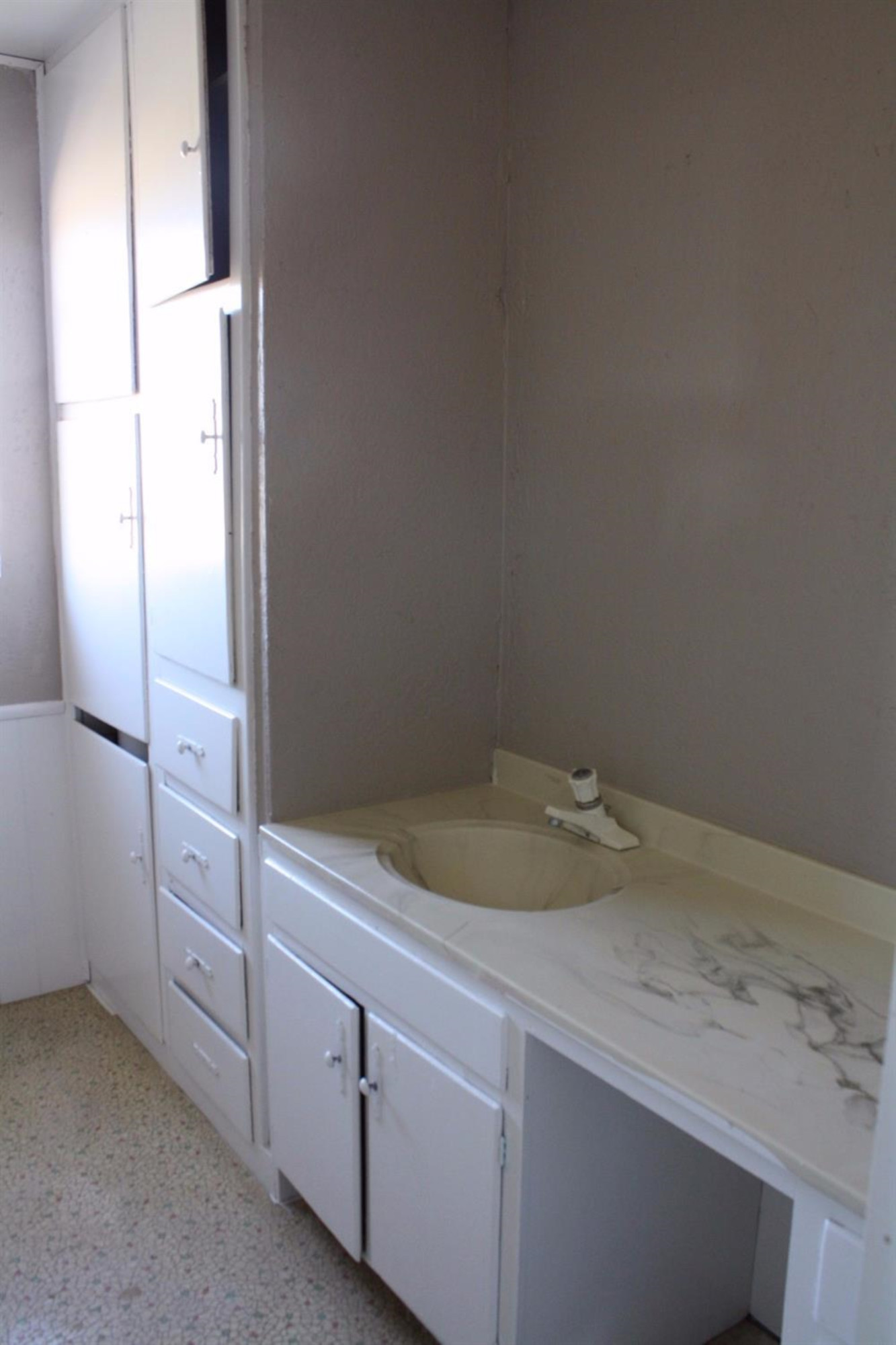 306 West 34th Plainview, TX 79072 - Photo 32 of 36 a bathroom with a granite countertop sink and white cabinets