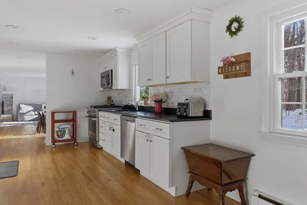 a kitchen with stainless steel appliances a refrigerator and wooden floor