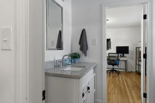 a room with lots of white furniture and wooden floor