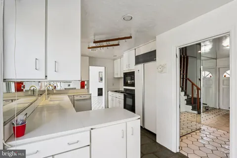 a kitchen with stainless steel appliances a sink a stove a refrigerator and cabinets