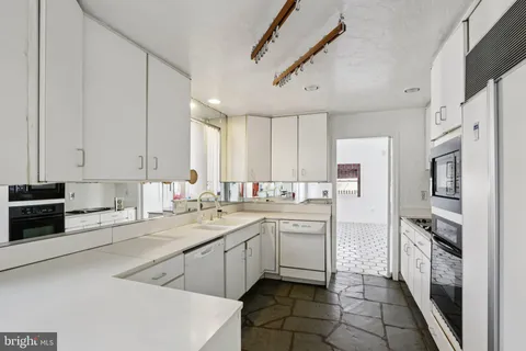 a kitchen with stainless steel appliances a stove a microwave and white cabinets