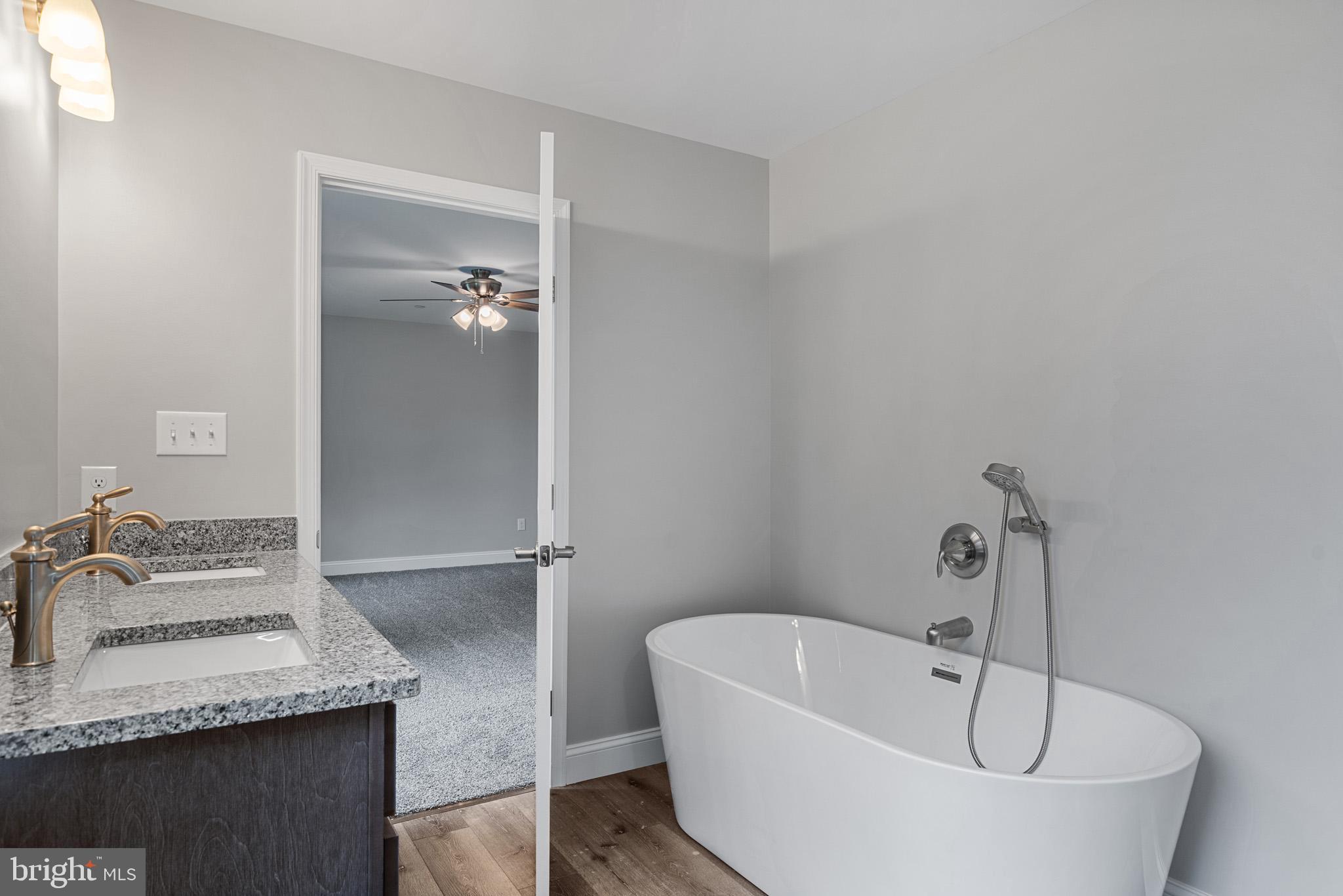 24215 Thistle Place Chaptico, MD 20621 - Photo 22 of 40 a bathroom with a tub sink and mirror