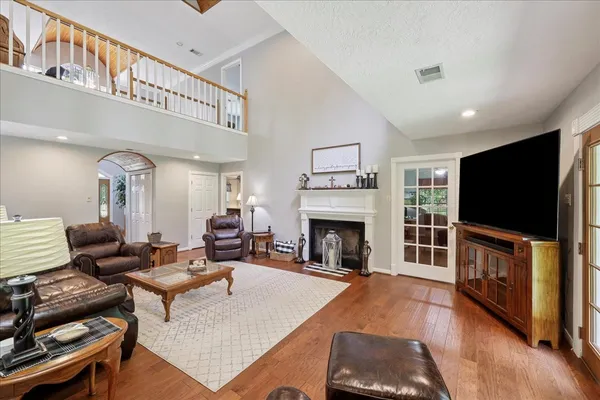 a living room with furniture a flat screen tv and a fireplace