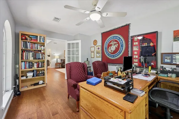 a view of a workspace with furniture and a bookshelf