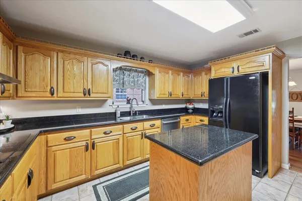 a kitchen with granite countertop stainless steel appliances a sink stove and refrigerator